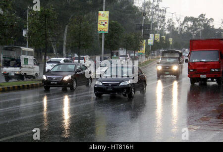 Commuters passing through road during heavy downpour of winter season, in Lahore on Wednesday, March 08, 2017.