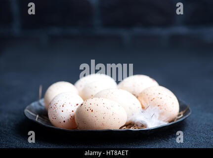 raw chicken eggs on plate and on a table Stock Photo