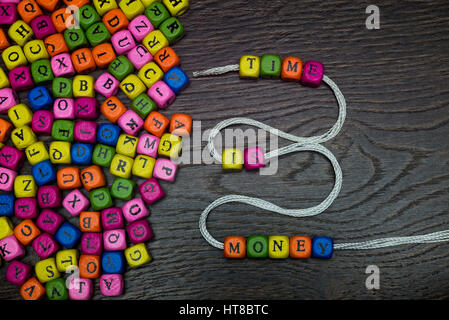 The words time money from beads collected on the floor. Stock Photo