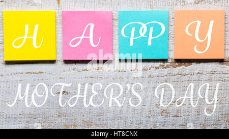 Happy Mother's day message written on colorful sticky notes, white vintage wooden background Stock Photo