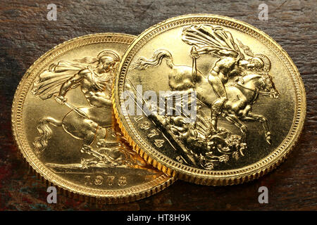 British Sovereign gold coins on rustic wooden background Stock Photo