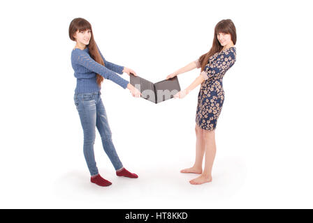 Portrait of two twins sisters with laptop on white background Stock Photo