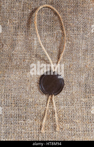 Sealing wax seal on sack background. Free space for text on old sealing wax sack. Stock Photo