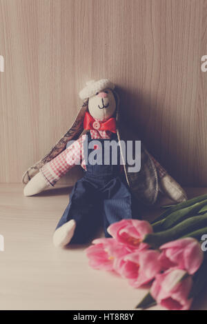toy hare with flowers on the beige background Stock Photo