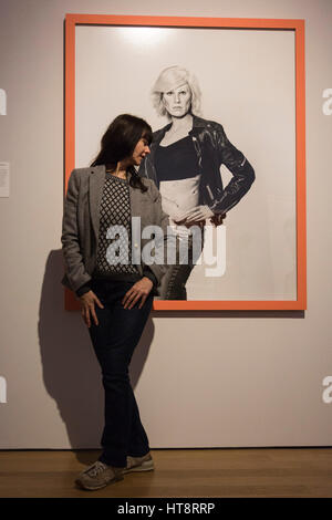 London, UK. 8 March 2017. Pictured: Gillian Wearing poses in front of herself made-up as Andy Warhol. On the opening of her new exhibition 'Gillian Wearing and Claude Cahun: Behind the Mask, Another Mask', Turner-Prize winning artist Gillian Wearing unveils her massive new portrait “Rock 'n’ Roll 70 wallpaper” a computer-generated impression displayed on an entire wall of the National Portrait Gallery. Sometimes working with forensic artists, or undertaking the technical work herself, Wearing has produced impressions of how she might age by showing the effects of plastic surgery, changing hair Stock Photo