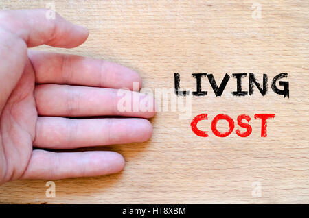 Human hand over wooden background and living cost text concept Stock Photo