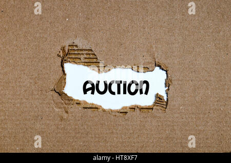 The word auction appearing behind torn paper Stock Photo