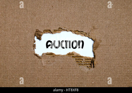 The word auction appearing behind torn paper Stock Photo