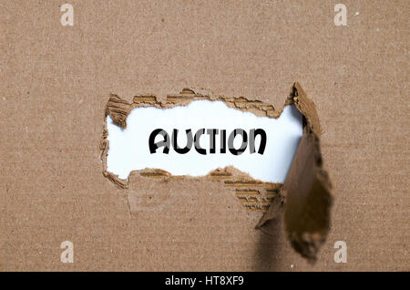 The word auction appearing behind torn paper Stock Photo