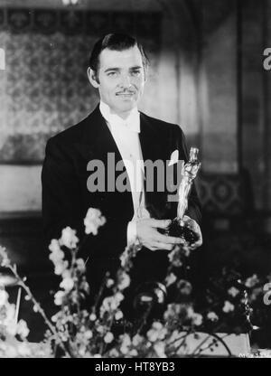 'Clark Gable, popular Metro-Goldwyn-Mayer star, with the gold statuette for the 'best work by an actor during 1934,' given him by the Academy of Motion Picture Arts and Sciences for his performance in 'It Happened One Night,' a Columbia picture.' Stock Photo