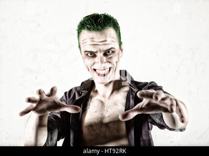 guy with crazy joker face, green hair and idiotic smike. carnaval costume. Stock Photo