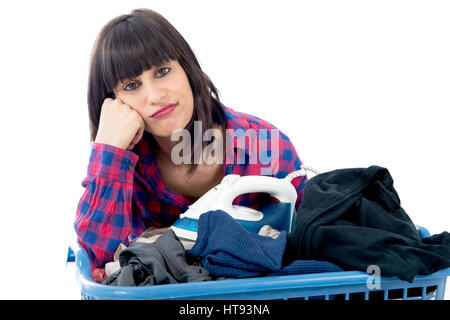 an unhappy young beautiful woman ironing clothes Stock Photo
