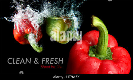 Splash water from water droping bell pepper mixed with focus  another bell pepper in black background and sample text with studio lighting. in black b Stock Photo