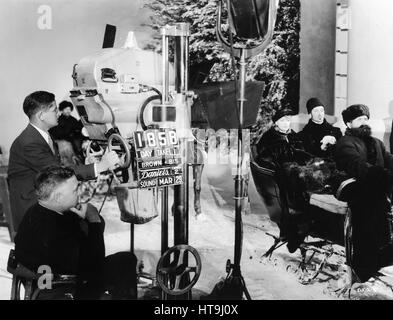 'Clarence Brown, seated in the foreground, directs Greta Garbo and Basil Rathbone, in a scene for the new Metro-Goldwyn-Mayer production, 'Anna Karenina.'' Stock Photo