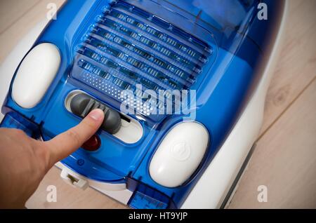 Hand switch sets the power efficiency of the vacuum cleaner. Energy saving and efficiency appliances. Stock Photo