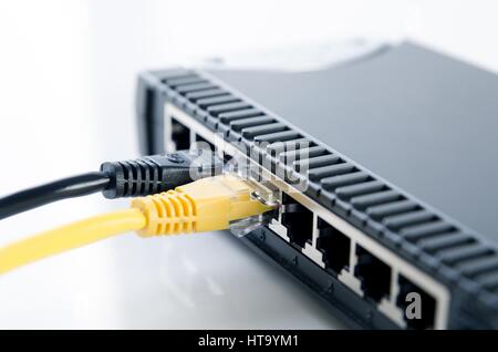 Network switch device and ethernet cables on white background Stock Photo