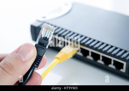 Network switch device and ethernet cables on white background Stock Photo