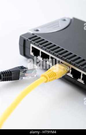 Network switch device and ethernet cables on white background Stock Photo