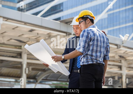 Architect, engineer, project manager or businessman point to building in the city with a blank plan as for construction Stock Photo