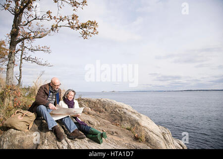 Mature couple reading a map near lake Stock Photo