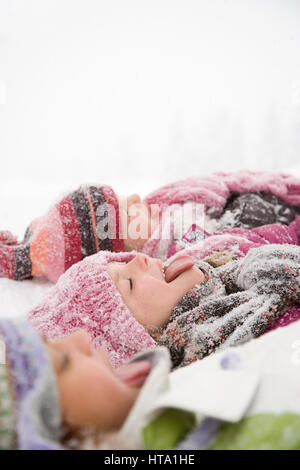 Children in snow sticking their tongues out Stock Photo