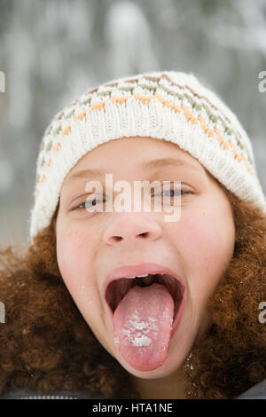 Girl with snow on her tongue Stock Photo