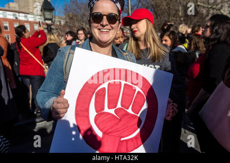 New York, USA. 8th Mar, 2017. Women marked International Women's Day - A Day Without a Woman, with a rally in Washington Square Park followed by a march. Many women wore red and took the day off as a general strike. Woman with a sign showing the symbol for Womann Power in red. Credit: Stacy Walsh Rosenstock/Alamy Live News