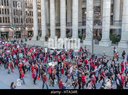 San Francisco, USA. 8th Mar, 2017. Demonstrators march past the old Federal Reserve building toward San Francisco ICE headquarters to protest Trump's deportation of undocumented immigrants after a rally on International Women's Day. Many demonstrators wore red to show support for the 'Day without a Woman' strike. Credit: Shelly Rivoli/Alamy Live News Stock Photo