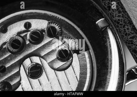 Mechanical men wrist watch with automatic winding, close-up fragment of open back side with self-winding mechanism details, black and white Stock Photo