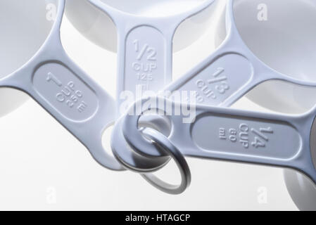 Detail four plastic measuring cups, sizes stamped on the handles. Stock Photo