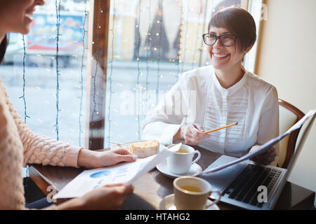 Happy economists discussing documents with financial data Stock Photo