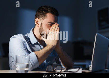 Fatigue man sitting in front of laptop at night Stock Photo