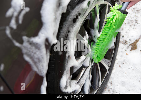 Close Up Of Hand Washing Car Wheel Using Brush Stock Photo