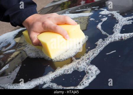 Close Up Of Hand Washing Car Bonnet Using Sponge Stock Photo
