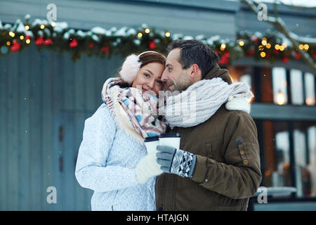 Happy lovers with drinks spending time outdoors Stock Photo