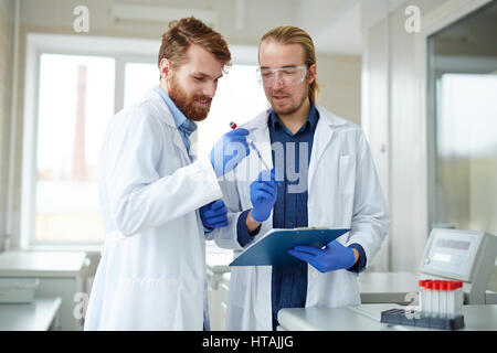 Two scientists learning chemical samples in lab Stock Photo