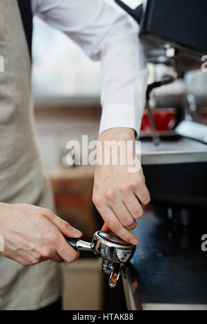 Barista grinding coffee beans in portafilter Stock Photo