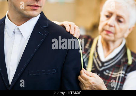 Businessman having his jacket sleeve measured Stock Photo
