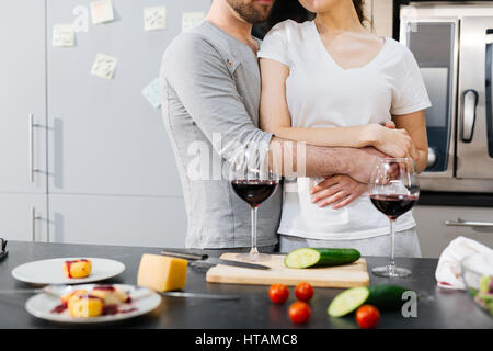 Young man embracing his wife by dinner table Stock Photo