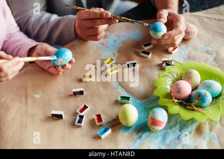 Man and woman painting eggs for religious holiday Stock Photo