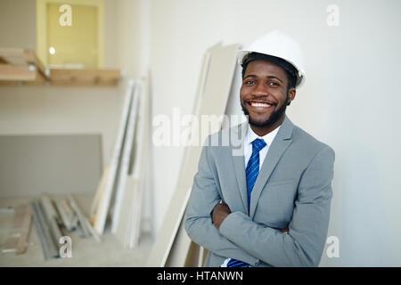 Smiling businessman in hardhat looking at camera Stock Photo