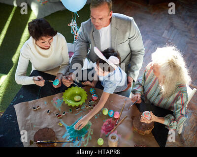 Parents, their son and senior female painting Easter eggs together Stock Photo