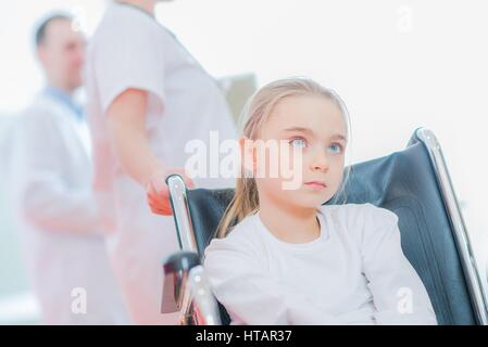 Caucasian Girl on the Wheelchair in the Hospital. Stock Photo