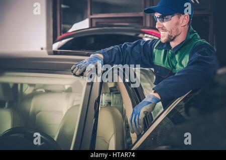 Happy Car Mechanic in His Small Garage Auto Service Shop. Small Business Concept. Stock Photo