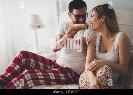 Romantic happy couple having breakfast in bed Stock Photo