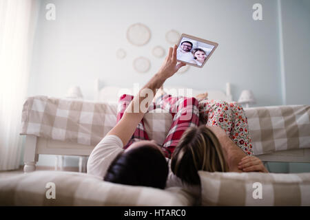 Loving couple taking selfies at home in pajamas Stock Photo