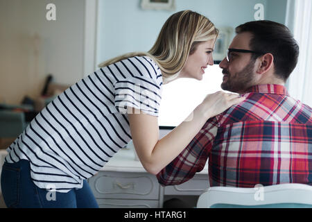 Supportive woman caring for husband working from home Stock Photo