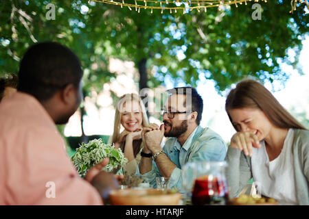 Happy young friends talking at leisure Stock Photo