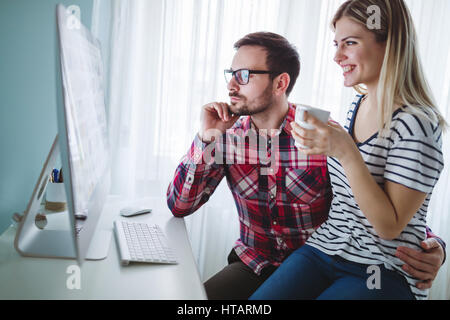 Creative man working from home with wife while drinking coffee Stock Photo
