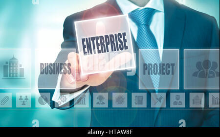 A businessman pressing a Enterprise button on a transparent screen. Stock Photo